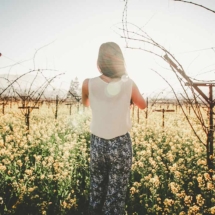 Woman standing in front of vineyard