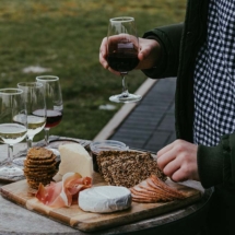 Man holding wine and selecting cheese